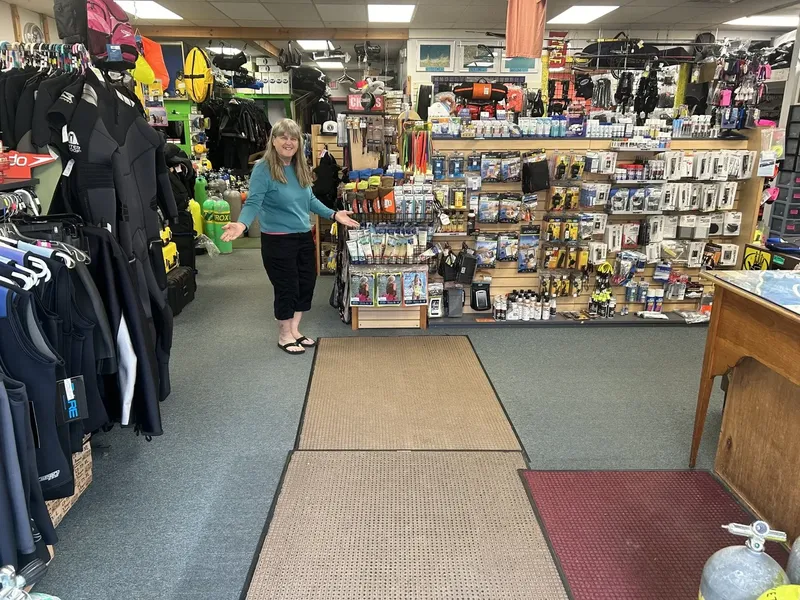 Intérieur d'un magasin de plongée avec une vendeuse souriante