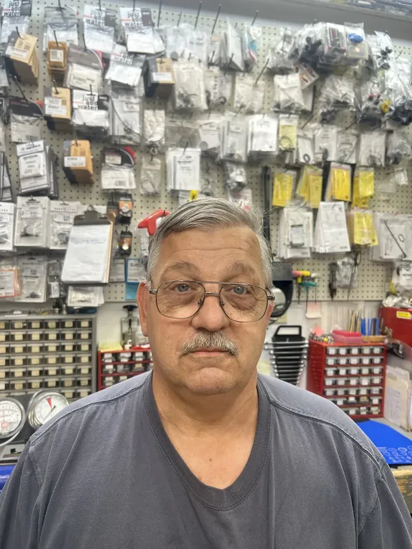 Homme devant un mur d'accessoires de plongée dans un magasin