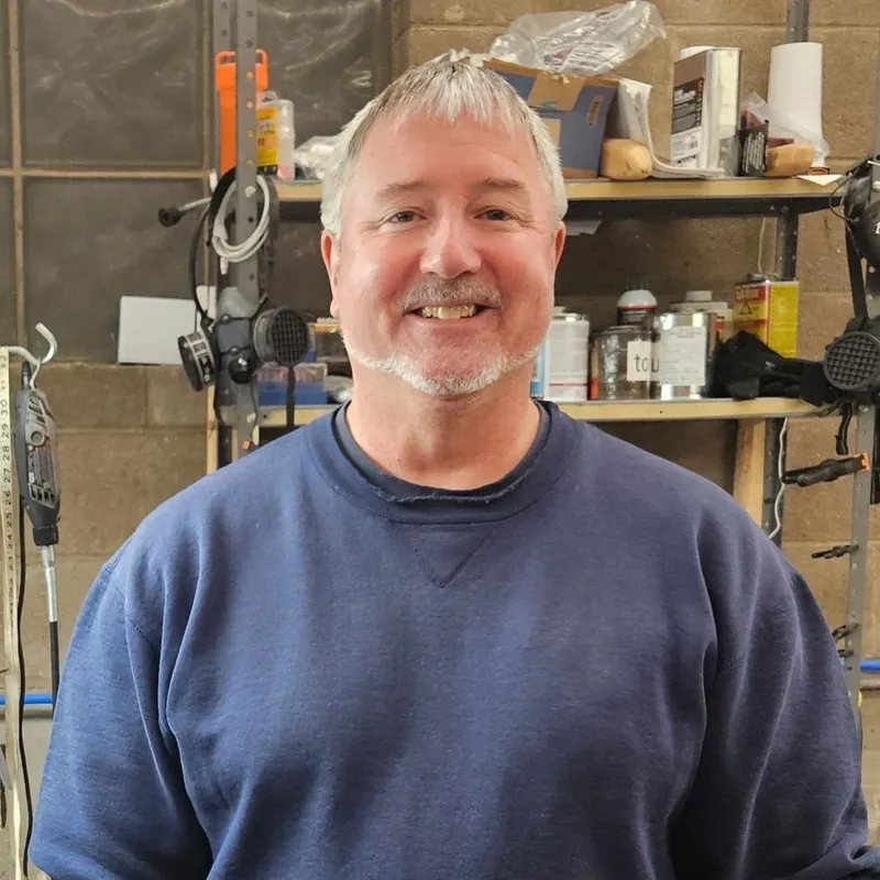 Portrait d'un homme souriant dans un atelier de plongée avec du matériel