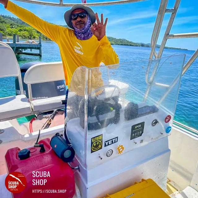 Homme souriant salue depuis un bateau de plongée en mer