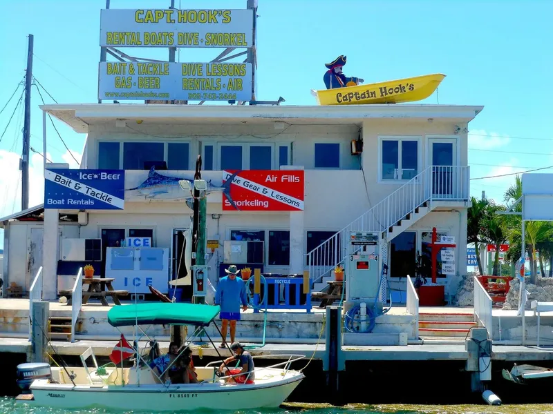 Façade d'un centre de plongée avec bateaux amarrés et personnes