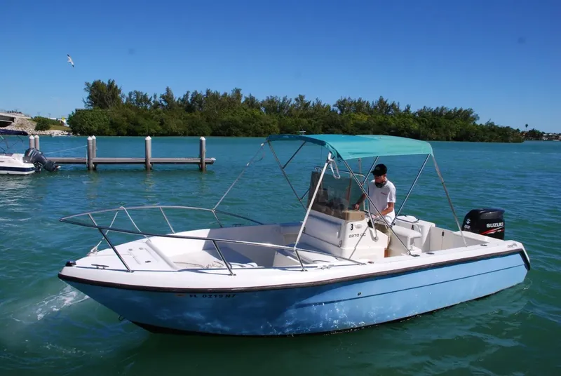 Un homme conduit un bateau bleu et blanc sur l'eau calme