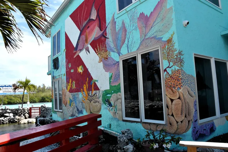 Façade d'un bâtiment avec une grande fresque marine colorée et détaillée