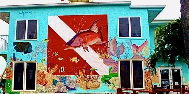 Façade d'un bâtiment avec une grande peinture de poisson et coraux