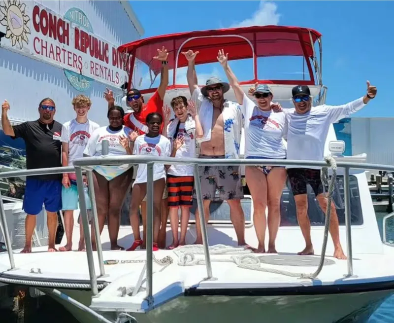 Groupe de personnes souriantes sur le pont d'un bateau de plongée