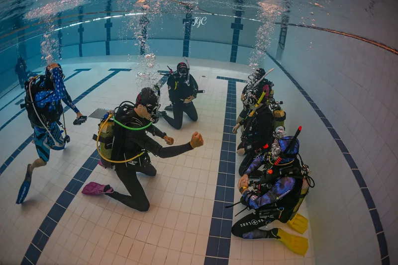 Plongeurs en formation dans une piscine, interaction et communication sous-marine