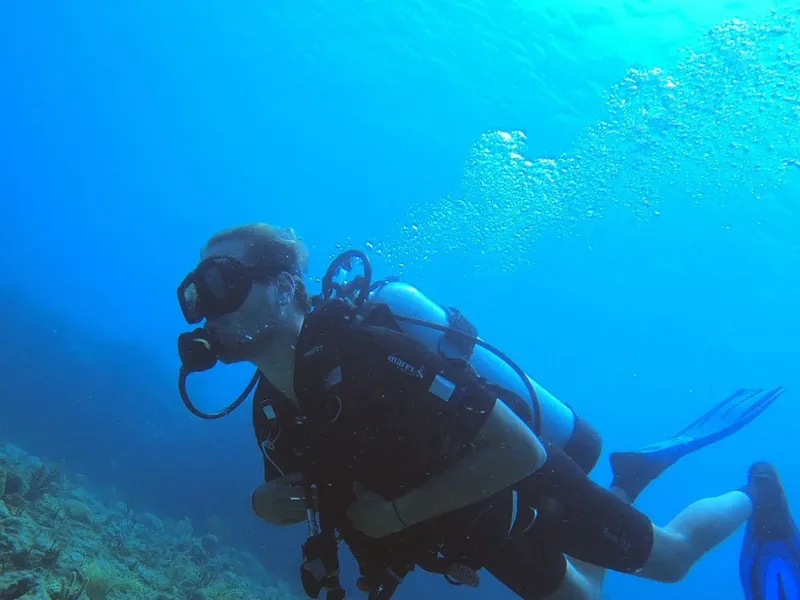 Plongeur en combinaison explore les fonds marins bleus avec son équipement