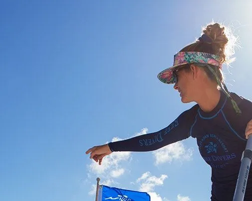 Femme portant un chapeau et des lunettes de soleil, regardant vers le bas