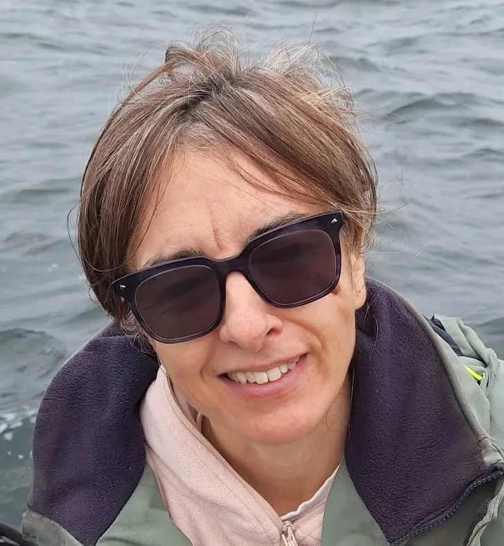 Portrait souriant d'une femme avec des lunettes de soleil sur l'eau