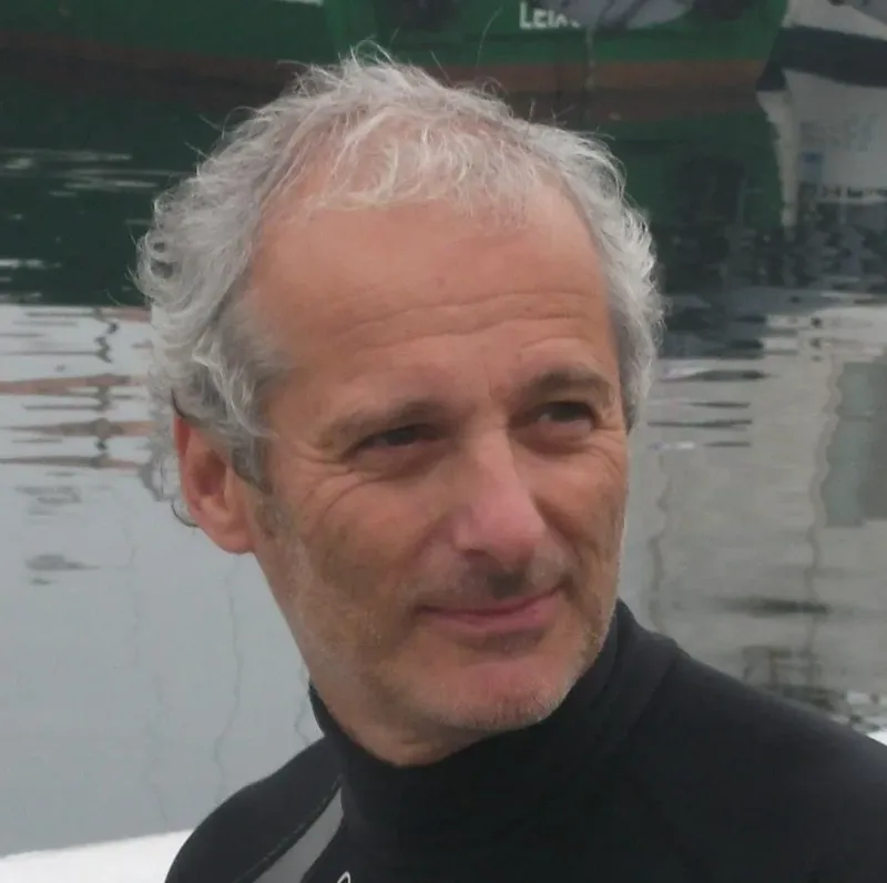 Portrait d'un homme souriant avec cheveux gris et combinaison de plongée