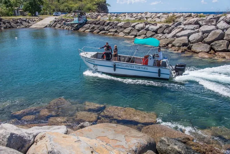 Bateau de plongée turquoise navigue sur une eau claire et calme