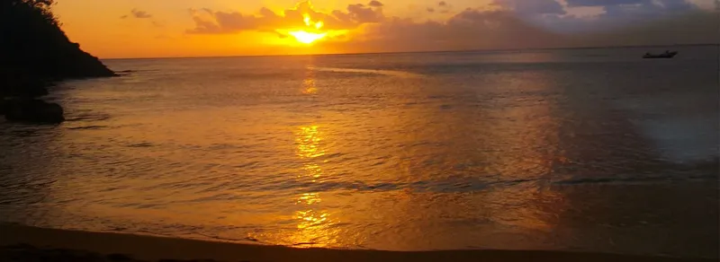 Coucher de soleil sur la mer avec un bateau au loin