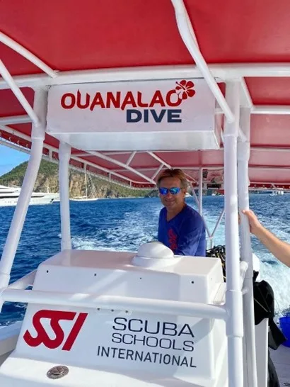 Homme souriant sur un bateau de plongée avec logo SSI et OuanaLac Dive