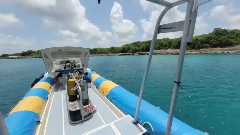 Bateau de plongée avec bouteilles, vue vers l'horizon et la côte