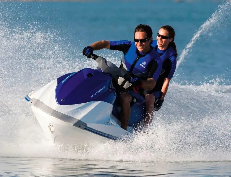 Deux personnes sur un jet ski bleu et blanc en mer