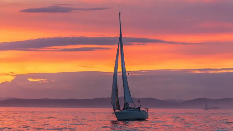 Voilier naviguant sur une mer calme au coucher du soleil