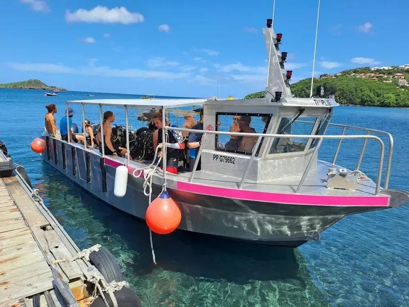 Bateau de plongée avec des passagers équipés près d'un quai