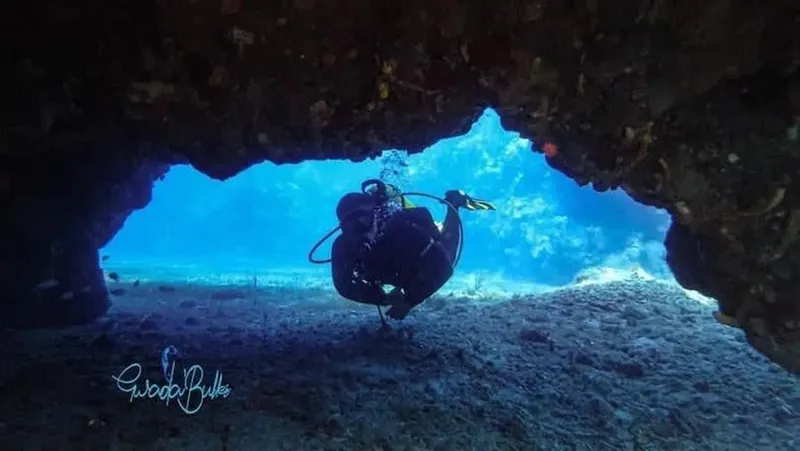 Plongeur explorant une grotte sous-marine avec une lumière bleue intense