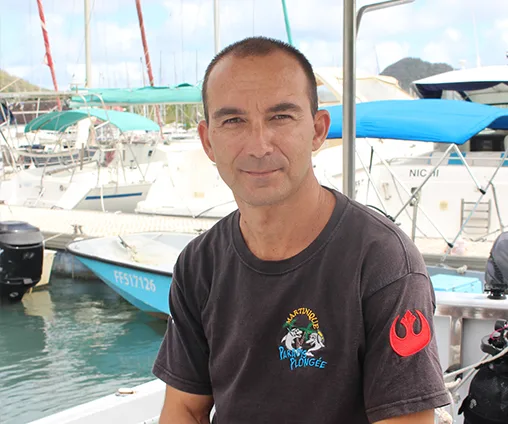 Homme souriant sur un bateau dans un port ensoleillé