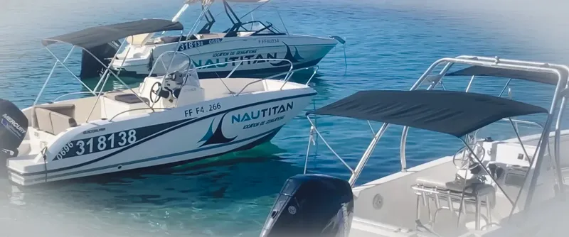 Plusieurs bateaux de plongée amarrés dans une eau turquoise claire