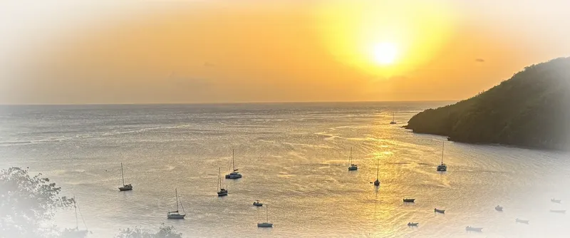Coucher de soleil sur la mer avec de nombreux voiliers amarrés