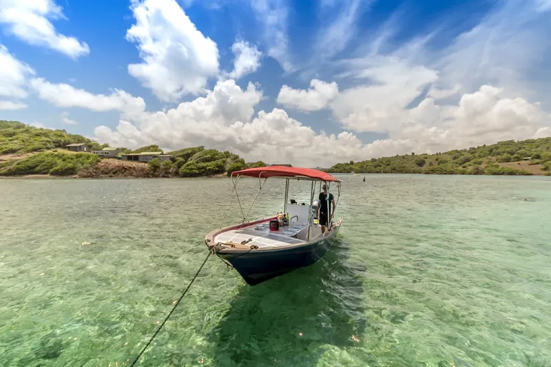 Bateau de plongée amarré dans une eau turquoise et claire