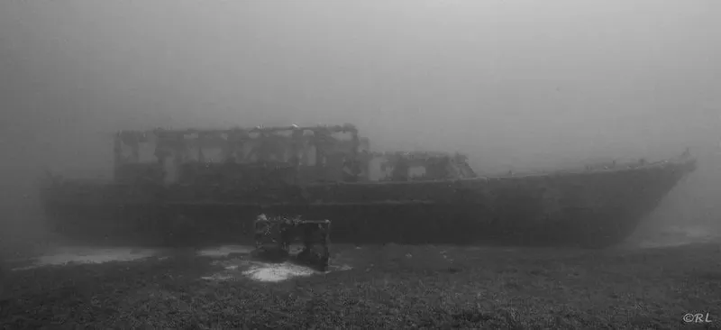 Epave de bateau rouillé reposant sur le fond marin brumeux