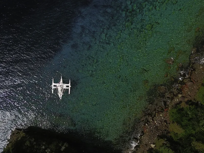Vue aérienne d'un bateau de plongée au-dessus d'eaux turquoise et rocheuses