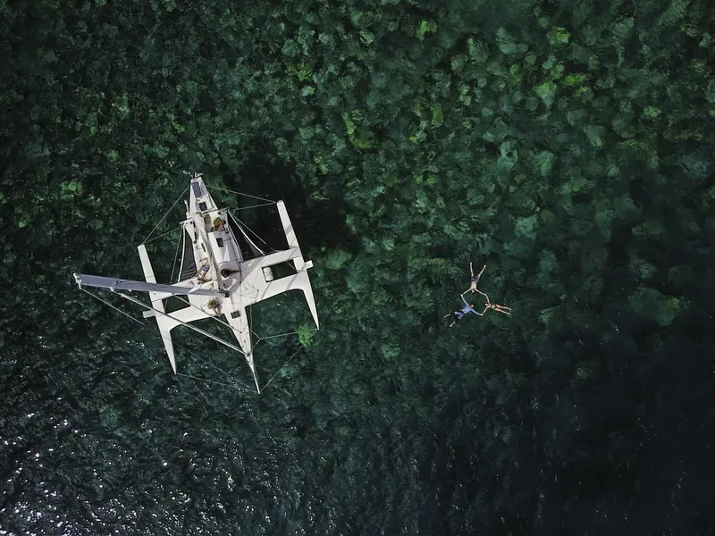 Vue aérienne d'un catamaran et de deux plongeurs dans l'eau