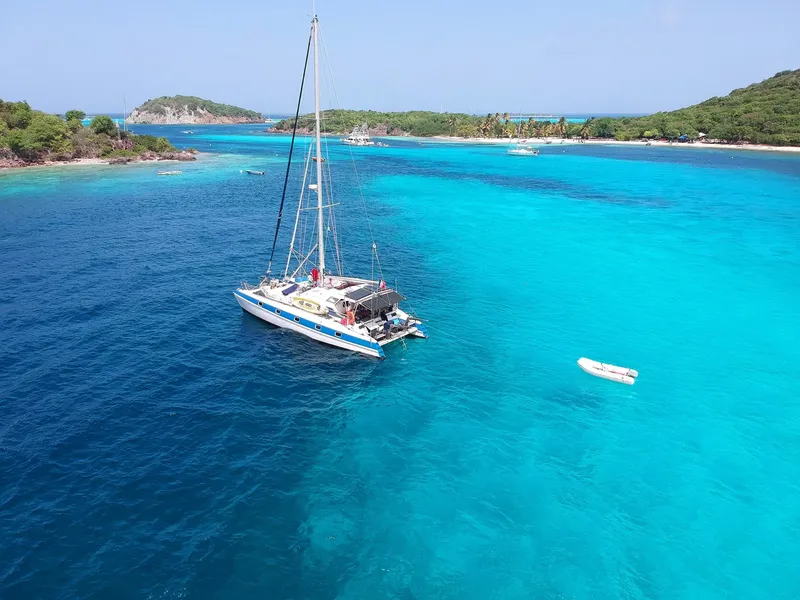 Catamaran blanc naviguant sur une mer turquoise et calme