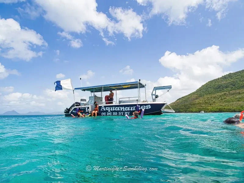Bateau de plongée bleu et blanc avec des personnes à bord en mer