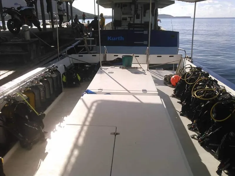 Bateau de plongée avec équipement, personnes et mer calme en arrière-plan
