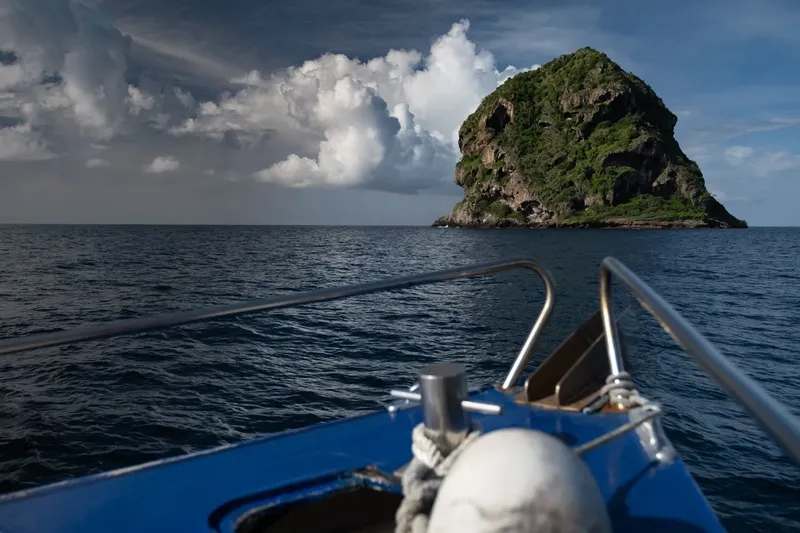 Vue d'un bateau en mer avec une île verdoyante à l'horizon