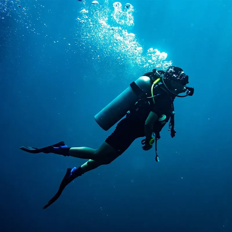 Plongeur en combinaison explore les profondeurs bleues de l'océan