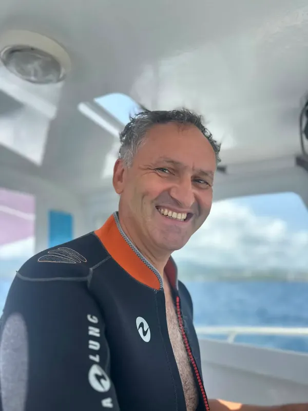 Homme souriant portant une combinaison de plongée sur un bateau