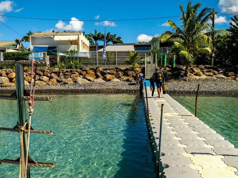 Ponton d'accès avec des plongeurs équipés devant le centre de plongée