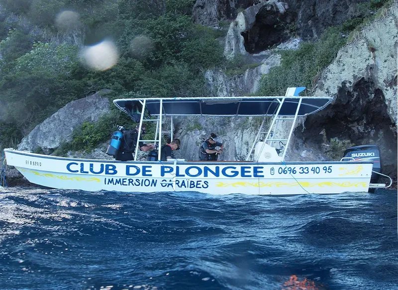 Bateau de plongée jaune et bleu sur une mer agitée ensoleillée