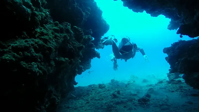 Plongeur explore une grotte sous-marine avec une lumière bleutée