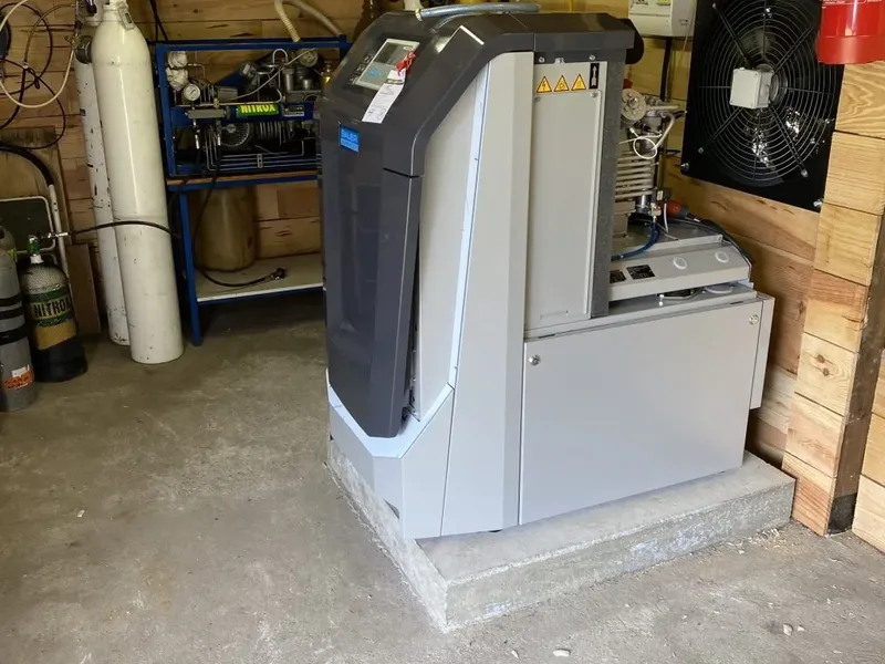 Compresseur de plongée gris et équipements dans un local technique