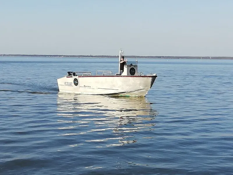 Bateau de plongée rouge naviguant sur une mer calme et ensoleillée