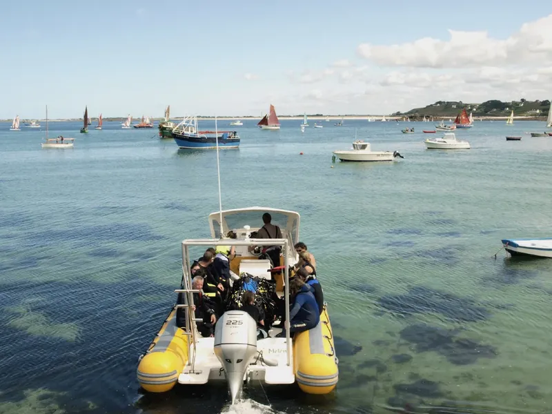 Groupe de plongeurs à bord d'un bateau semi-rigide en mer