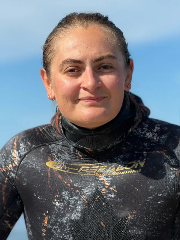 Portrait d'une femme souriante portant une combinaison de plongée noire