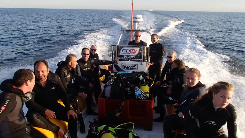 Groupe de plongeurs en combinaison sur un bateau en mer