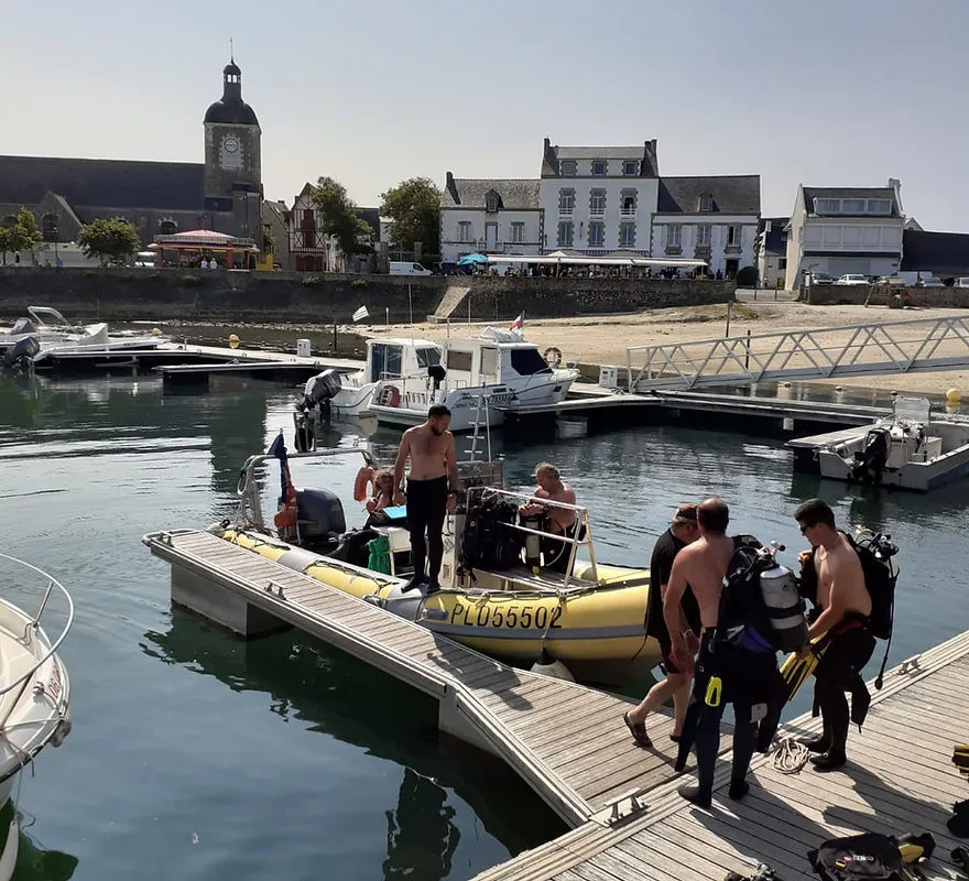 Plongée : des personnes équipées montent à bord d'un bateau jaune