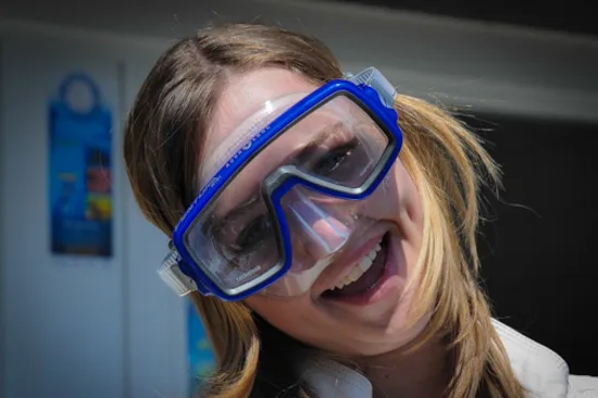 Femme souriante portant un masque de plongée bleu sur son visage