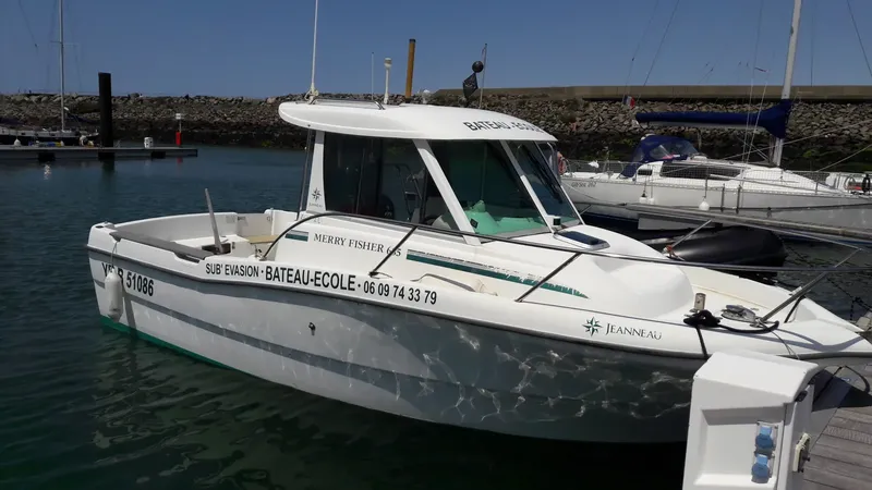 Bateau de plongée amarré dans un port ensoleillé avec inscription
