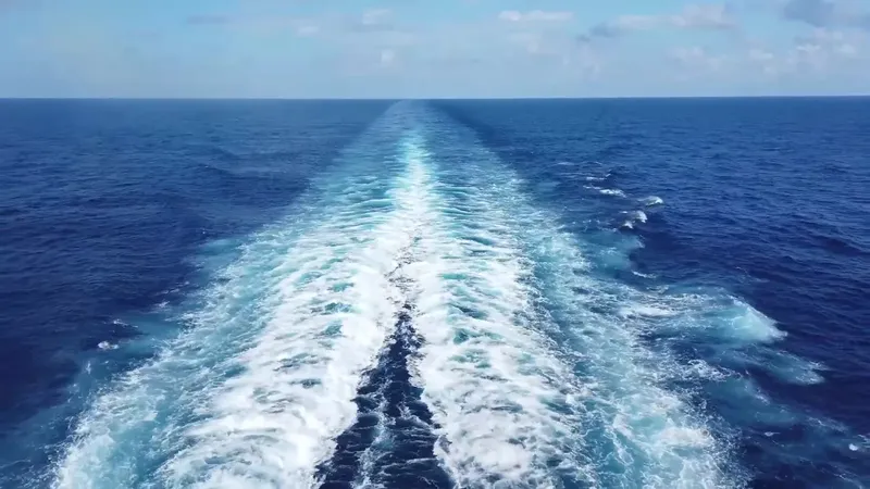 Sillage d'un bateau naviguant sur une mer bleue calme et dégagée