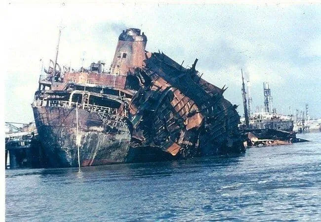 Épave de navire rouillé à quai, vue d'ensemble en journée