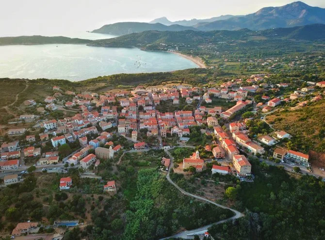 Vue aérienne d'un village côtier avec la mer et montagnes