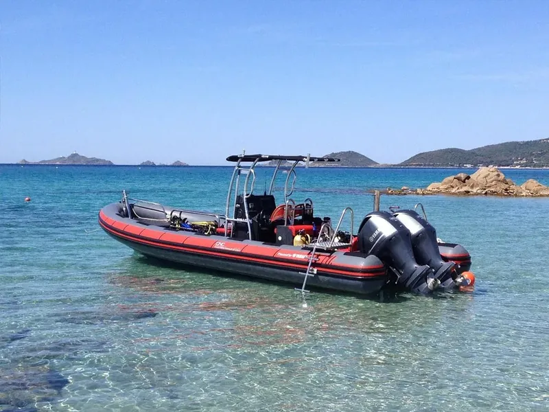 Bateau semi-rigide amarré dans une eau turquoise avec équipement de plongée